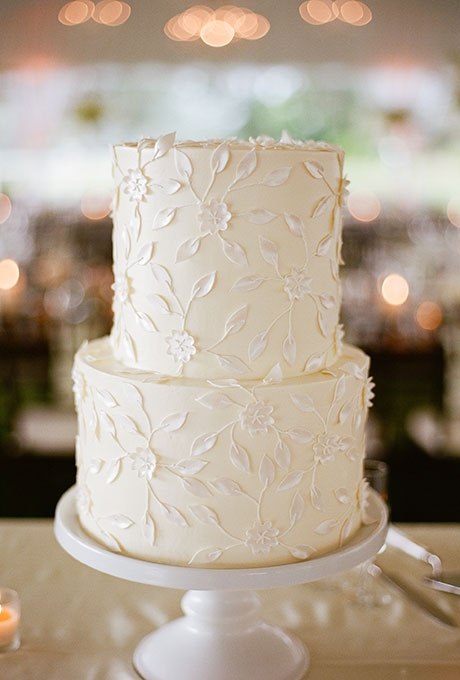 A two-tier white wedding cake with delicate flower details created by Jim Smeal.